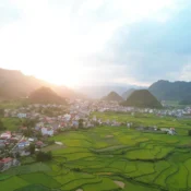 A green valley and town between limestone hills in the August evening light