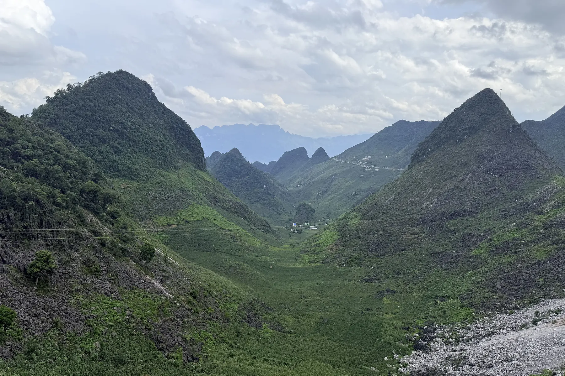 Green summer valley surrounded by limestone mountains in Ha Giang