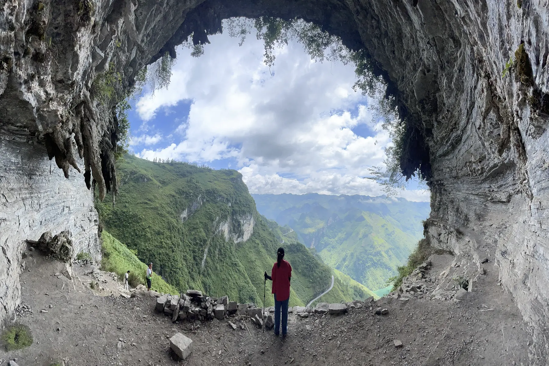 Karst cave opening onto a green valley in the Dong Van Karst Plateau
