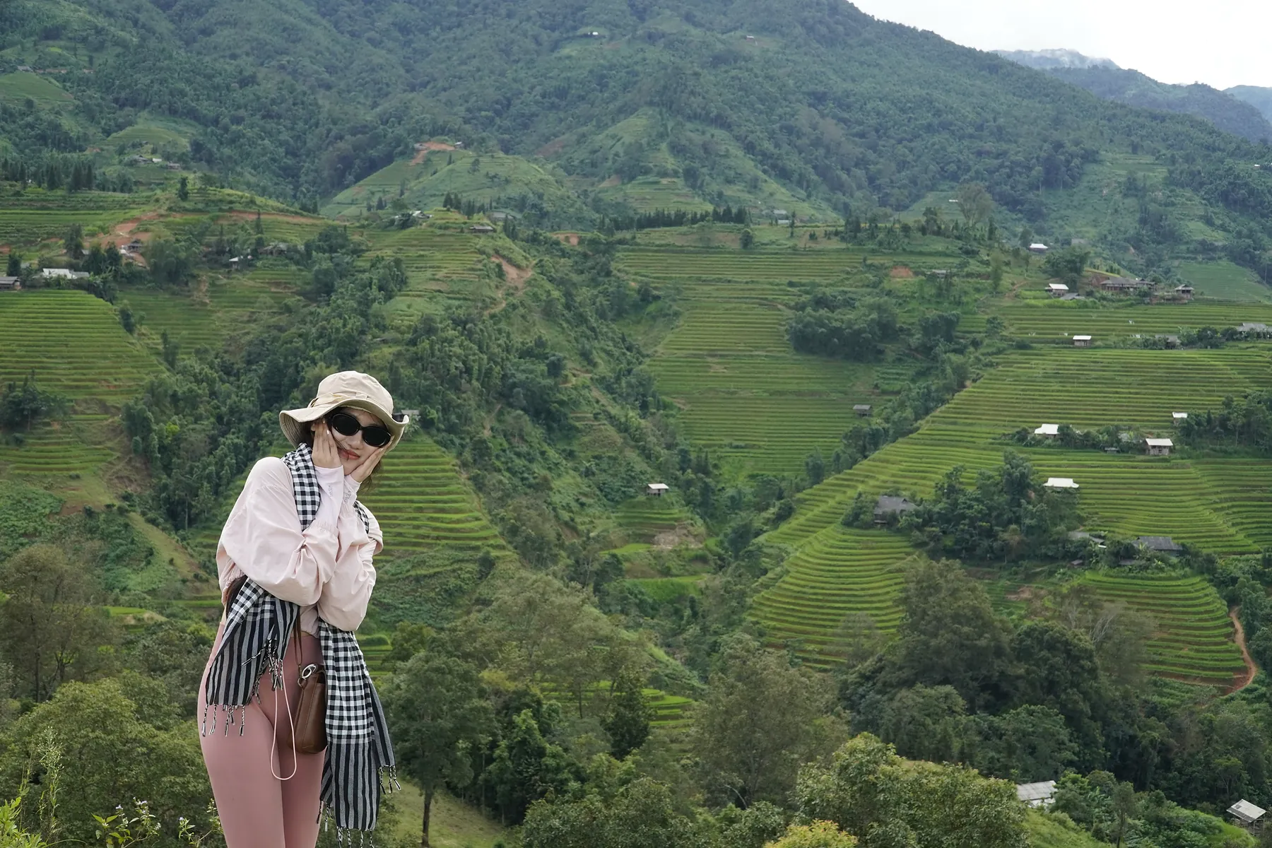 Traveller looking across green rice terraces in western Ha Giang