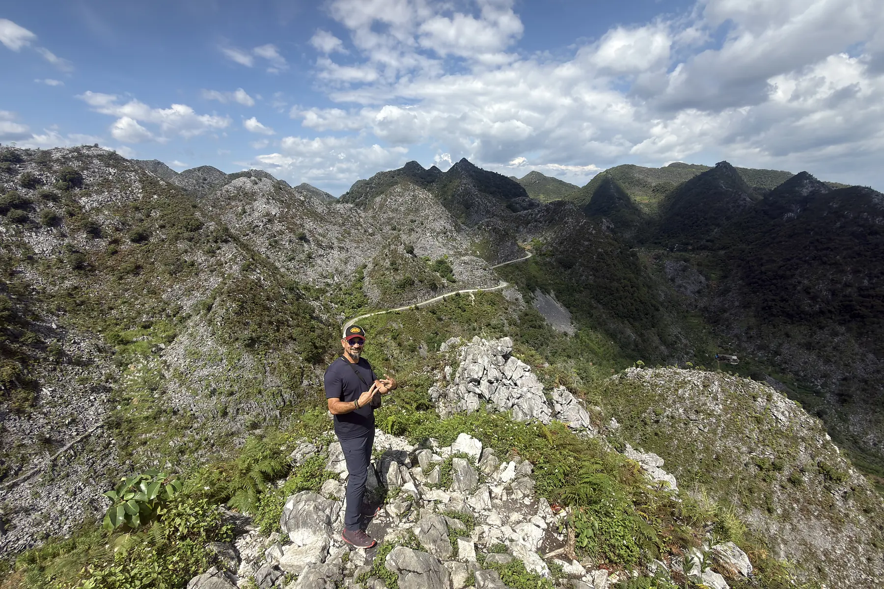 Traveller walking on rocky terrain in the Dong Van Karst Plateau